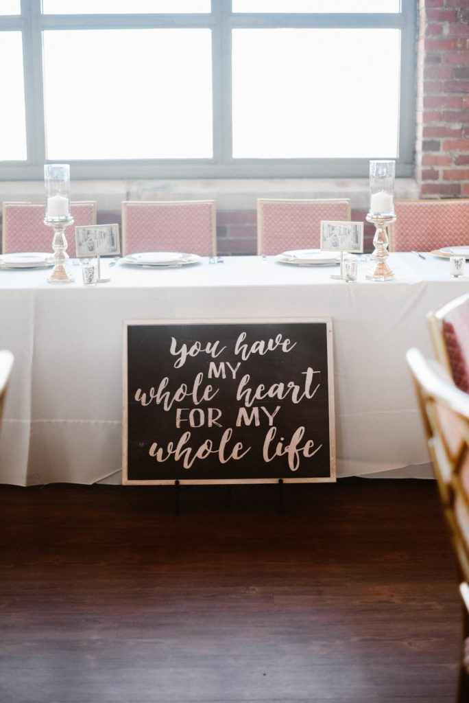 head bridal table set up and decor at ariel international center. There is a sign in front of the table that says "you have my whole heart for my whole life"