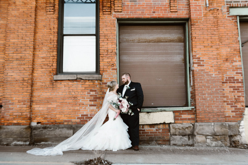 Bride and Groom Portrait at Ariel International in front of brick wall
