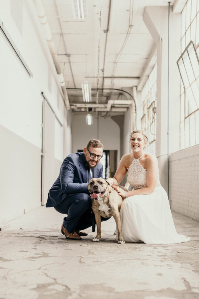 bride and groom in hallway with their dog at the lake erie building