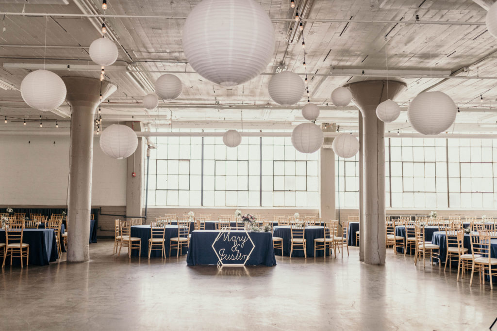 wedding reception table set up at the lake erie building with white spheres hanging from ceiling