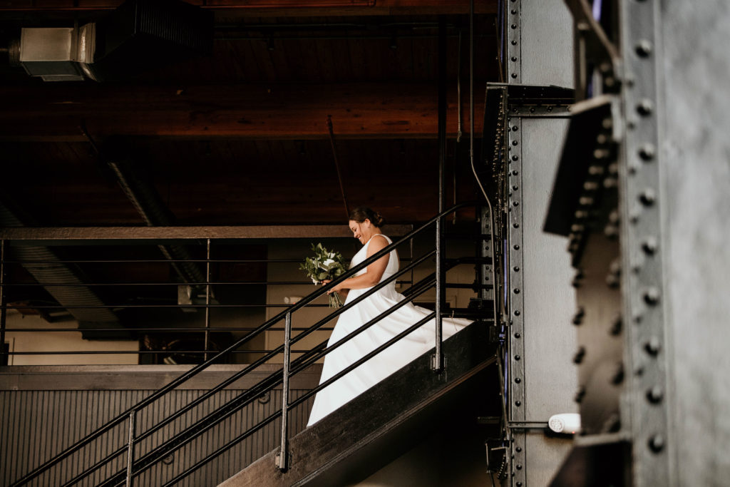 bride walking down steps at industrial wedding venue