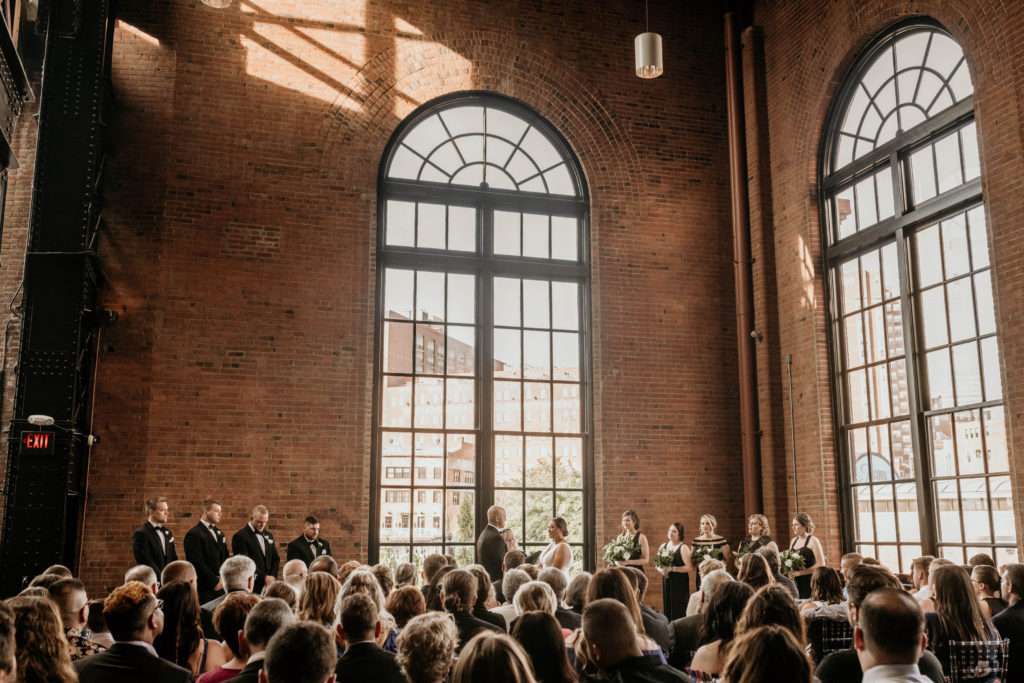 wedding ceremony, bride and groom standing in front of large window