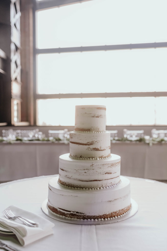 white industrial wedding cake with copper gold detail