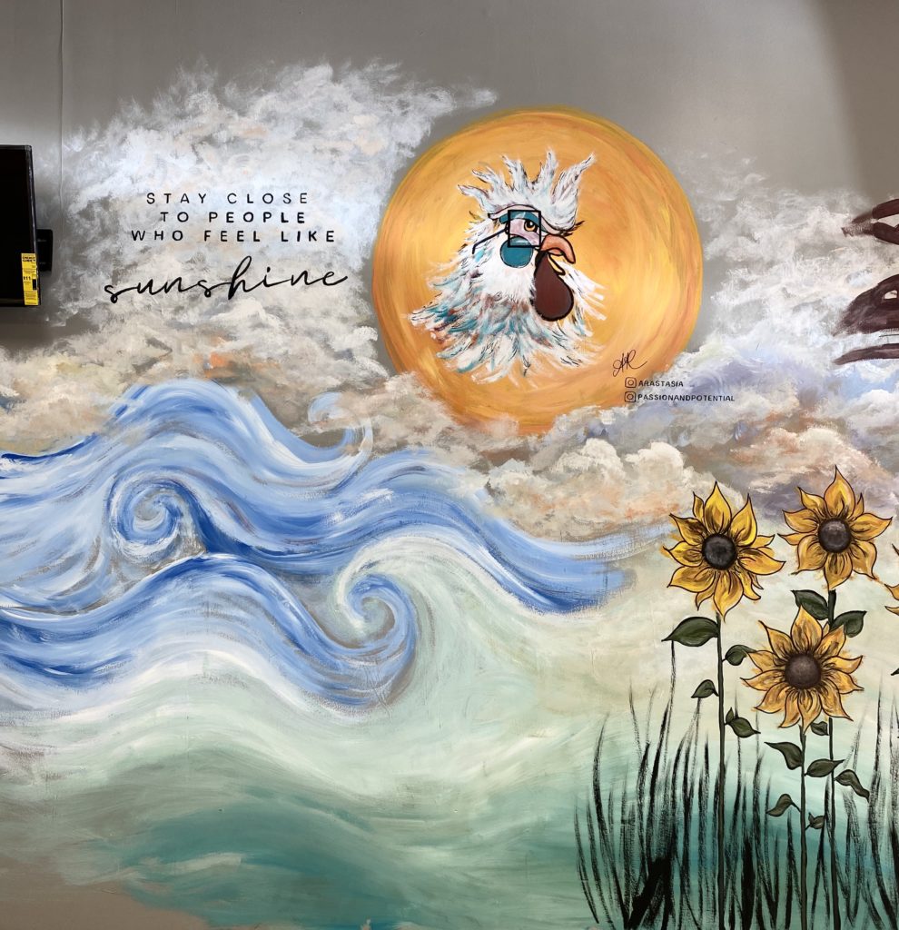 mural at the cracked egg in canton ohio. The mural contains clouds, flying pancackes, sunflowers, sun, and a chicken